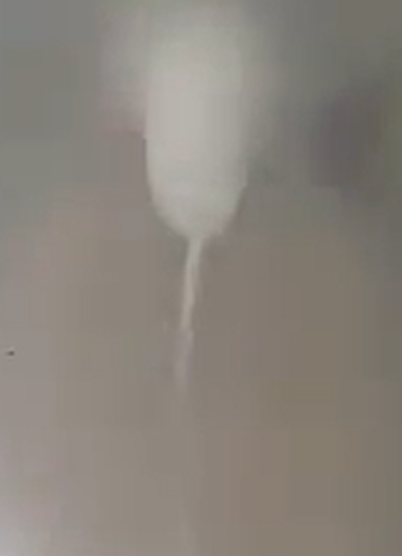 A tornado is forming.  A round little blob of cloud has a
needle-shaped extension below.
